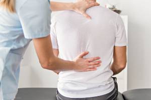 female doctor examining lower back for injury