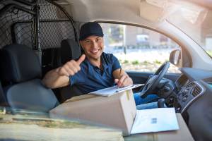 smiling delivery driver writing on clipboard