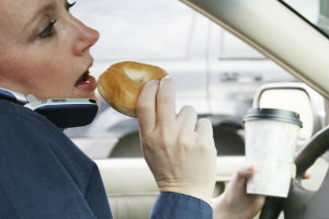 eating bagel using phone while driving