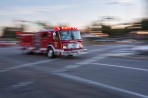 red firetruck racing through intersection