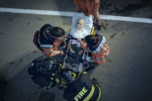 paramedics strapping woman to stretcher