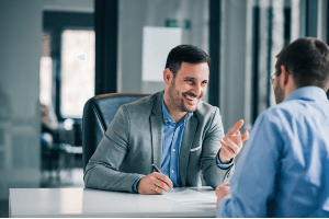 meeting at table with insurance agent smiling