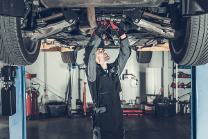 mechanic under car raised up on a platform