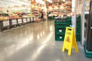 grocery store with wet floor sign near produce